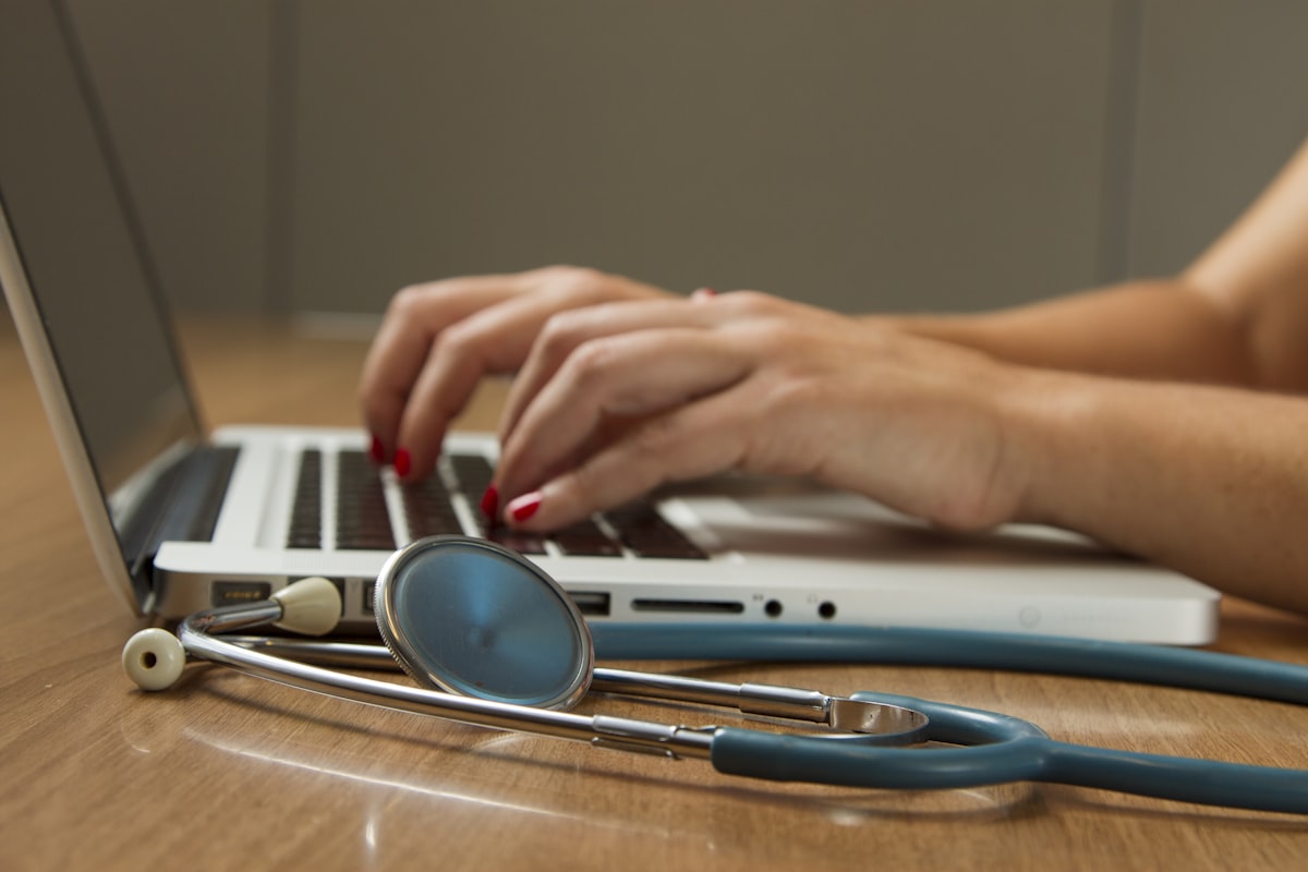 Indian nurse working at a hospital desk in Australia reviewing patient records and nursing job opportunities