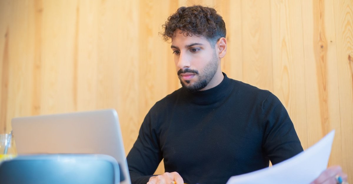 Skilled worker in Australia reviewing documents and a laptop while checking 189 visa requirements