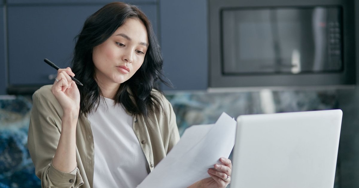 Woman reviewing residence and payslip documents at home while preparing a subclass 190 visa nomination in Victoria