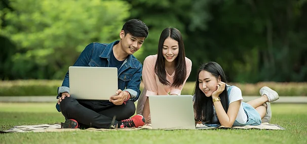 Students studying outdoors with laptops guided by study abroad consultants in Kochi